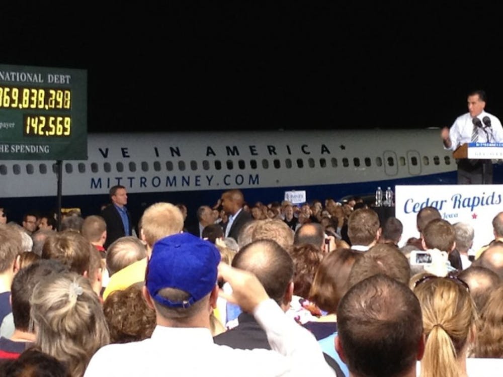 Mitt Romney addresses a crowd in Cedar Rapids, Iowa, on October 24, 2012, with a debt clock at his side and his campaign plane parked behind him. (Lesley Clark/MCT)