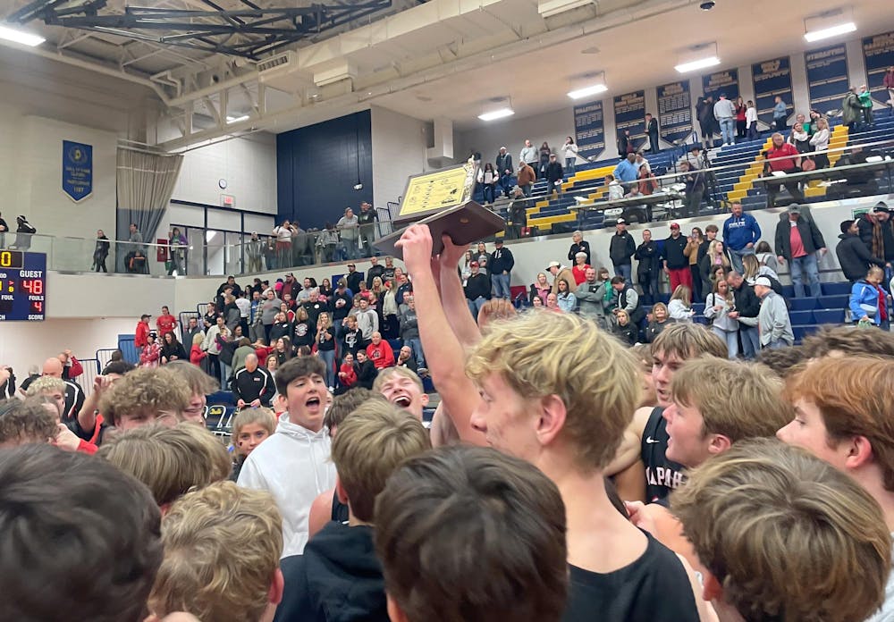 A Wapahani boys' basketball player holds the trophy Jan. 18 after winning the Delaware County boys' basketball tournament. The Raiders have won the event six times in the last 15 years. Zach Carter, DN. 