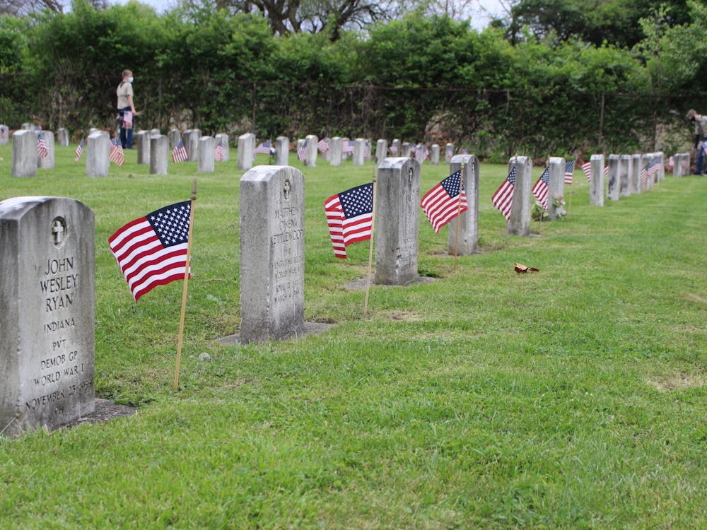 Boy Scouts and their families plant flags beside each headstone May 21, 2020, at Beech Grove Cemetery. Scouts in Muncie leave flags before Memorial Day in remembrance of fallen veterans. Jenna Gorsage, DN