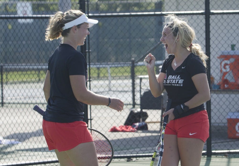 Junior Bethany Moore and senior Courtney Wild celebrate during the doubles match against Butler for the Fall Dual on Sept. 20 at the Cardinal Creek Tennis Center. DN PHOTO BREANNA DAUGHERTY 
