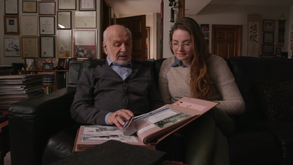 <p>Nicole Lehrman and her grandfather Gabriel DeLobbe look at old pictures in the documentary "Saboteur." Current Fort Wayne resident DeLobbe took pictures during World War II while he sabotaged enemy forces in the Belgian army. <strong>Chris Flook, Photo Courtesy</strong></p>