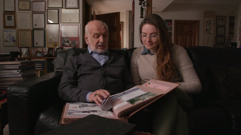 Nicole Lehrman and her grandfather Gabriel DeLobbe look at old pictures in the documentary "Saboteur." Current Fort Wayne resident DeLobbe took pictures during World War II while he sabotaged enemy forces in the Belgian army. Chris Flook, Photo Courtesy