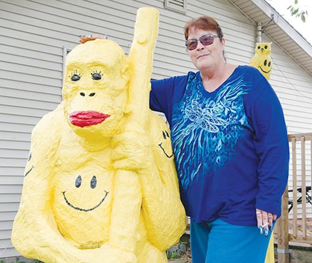 Kathie Hathaway stands next to a large smiley-faced gorilla statue, just one of hundreds of smiley faces that decorate the exterior of her home. The statue is important to Hathaway because it is a close tie to her niece, BB, who passed away over a week ago. DN PHOTO COREY OHLENKAMP