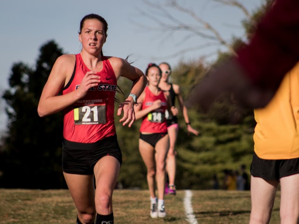 Freshman Juliana Stogsdill runs down the backstretch of the cross country meet as spectators cheer the runners on Oct. 18, 2019, at the Muncie Elks Golf Corse. Ball State Finished first overall for the women with a perfect score. Eric Pritchett, DN