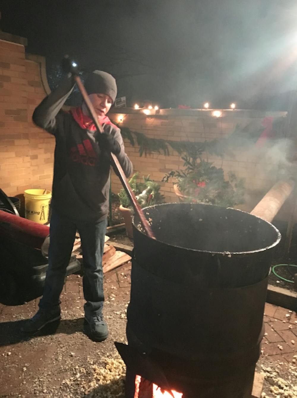 <p>Ashton Pauley, 12, stirs kettle corn in a big pot at the Minnetrista Enchanted Luminaria Walk on Dec. 4. Ashton was helping his great uncle and grandpa out at the event to raise money&nbsp;to buy children with disabilities tricycles. <em>DN PHOTO MICHELLE KAUFMAN</em></p>