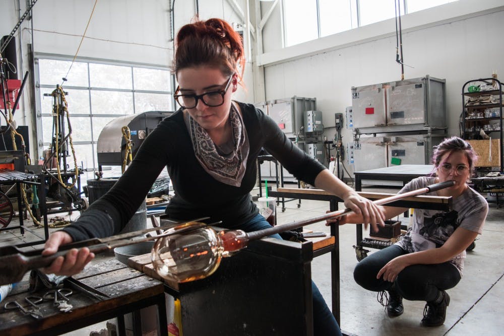 <p>Ally Burch, a graduate student, works on a glass piece with Kat Rudolph at the Marilyn K. Glick Center for Glass. <strong>Stephanie Amador, DN</strong></p>