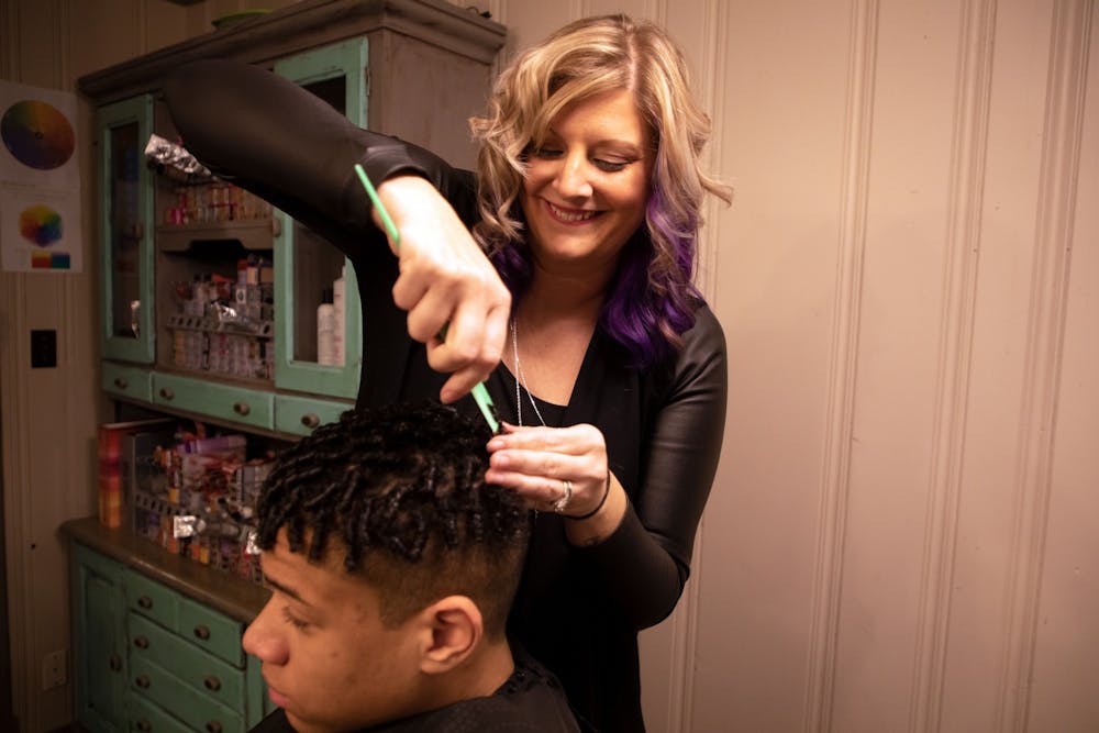 Erica Robinson Moody laughs while doing her son Brooklyn's hair Jan. 27. Erica's mission statement for her classes is "bridging the cultural gaps in the beauty community," and she is very focused on cultural hair education. Maya Wilkins, DN

