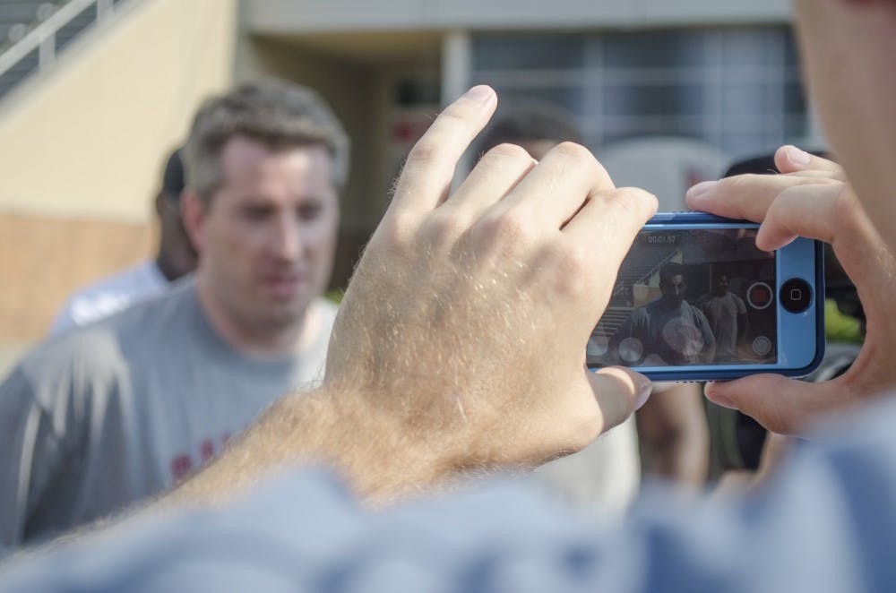 Tom St. Meyer, reporter for The Muncie Star Press takes a video of Brian Hardin before he completed the ice bucket challenge on Aug. 18 at Scheumann Stadium. DN PHOTO BREANNA DAUGHERTY