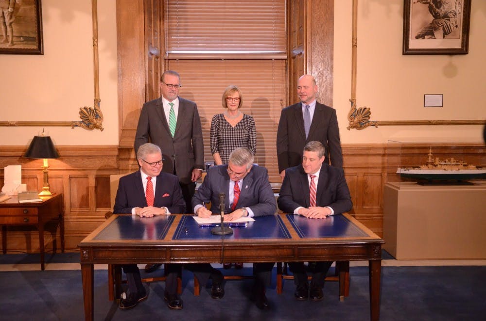 <p>Indiana Gov. Eric Holcomb signs Senate Bill 1, which allows Sunday alcohol carryout sales Feb. 28 at the Indiana Statehouse.<strong> Senator Ron Alting, Photo provided</strong></p>
