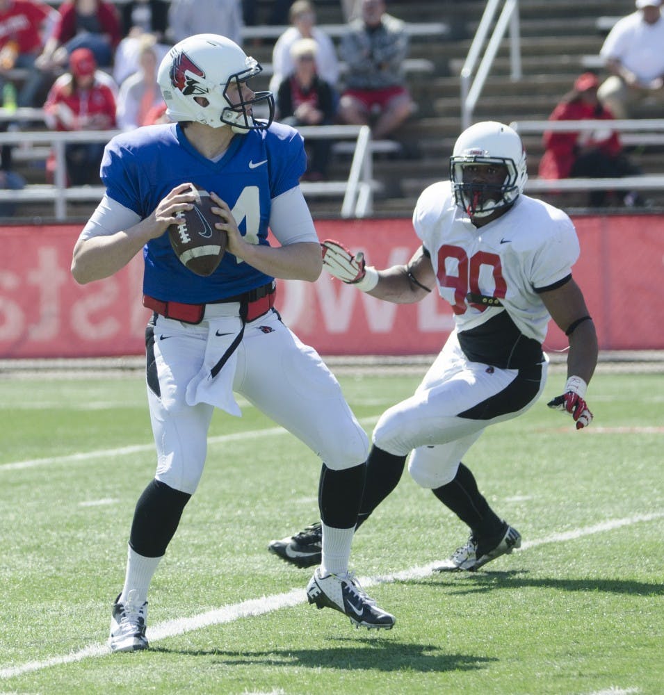 Defensive lineman Daniel Garces prepares to tackle redshirt freshman quarterback Jack Milas during a pass attempt in the spring football game on April 19 at Scheumann Stadium. The defense beat the offense 44-22. DN PHOTO BREANNA DAUGHERTY