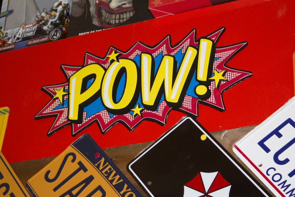 A “Pow!” sign hangs in Aw Yeah Comics on March 17. The shop is full of comic references such as this. (Briana Hale // DN)