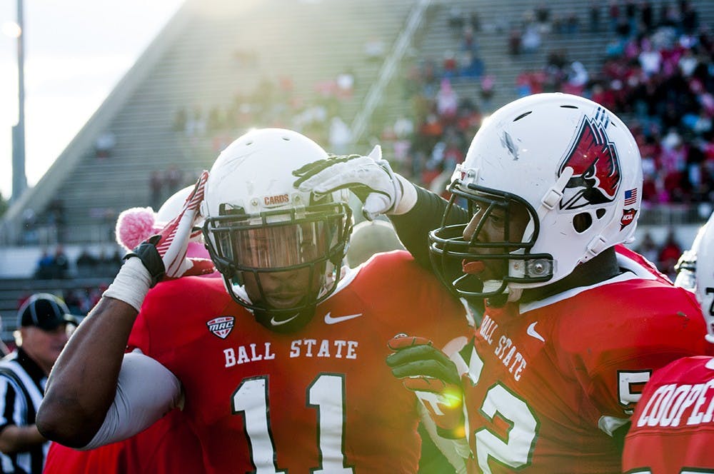 Defense end Nick Miles, right, congratulates defensive end Jonathan Newsome during the game against Northern Illinois on Oct. 6, 2012. Both consider each other good friends and have been defensive line starters since 2012. DN FILE PHOTO JONATHAN MIKSANEK