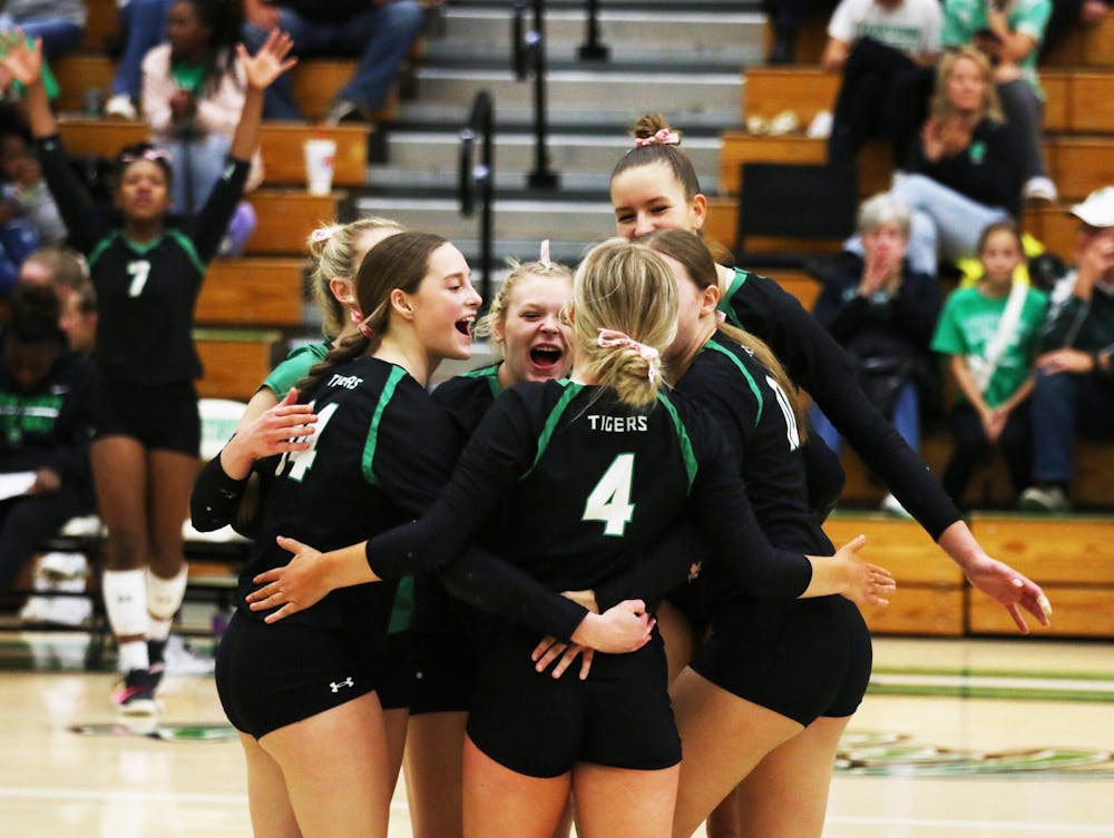 Yorktown volleyball players celebrate after scoring Oct. 7 in the Tigers' last home game against Burris. Zach Carter, DN