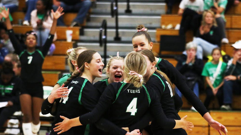Yorktown volleyball players celebrate after scoring Oct. 7 in the Tigers' last home game against Burris. Zach Carter, DN