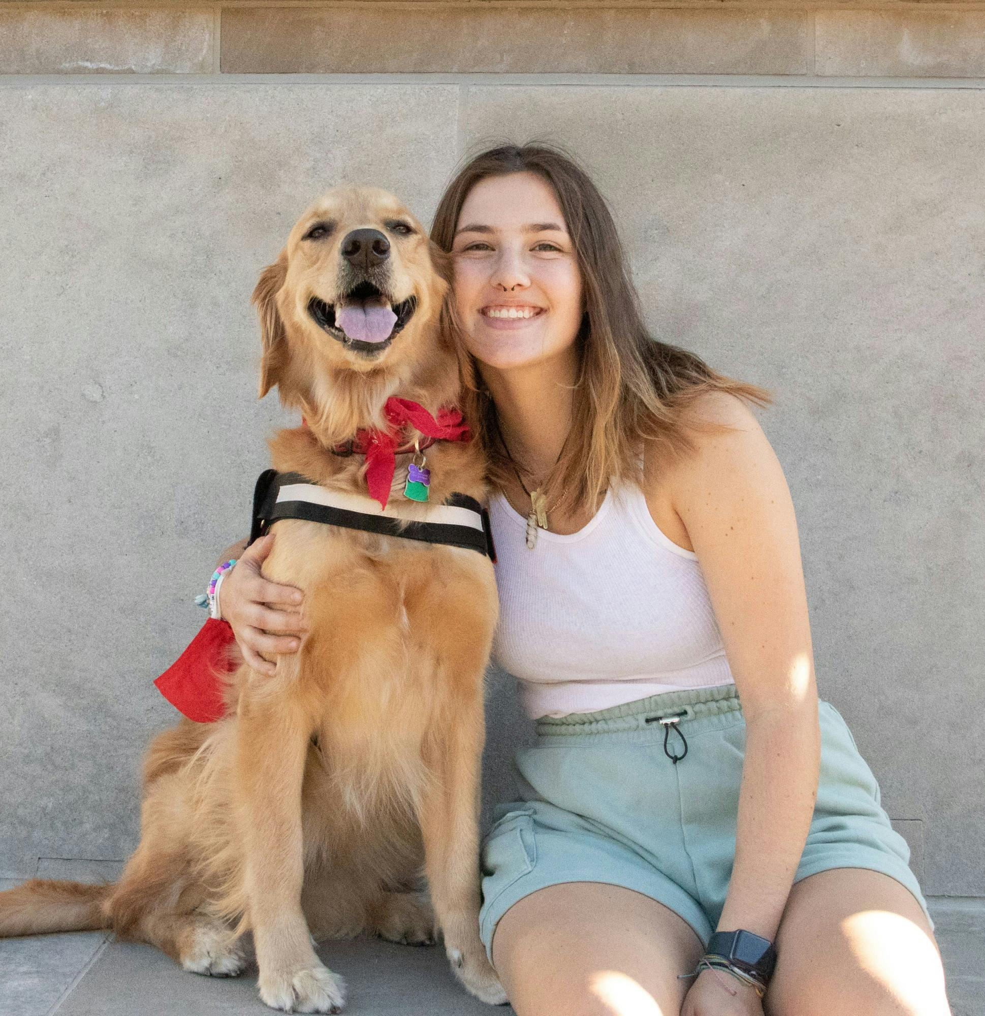 Sara Harmeyer and her golden retriever, Rey, sit proudly under the bells of Shafer Tower Oct. 1. “[Rey] goes longboarding with me and we go on lots of walks,” Harmeyer said. “She also gets lots of attention and play time from me and my friends.” Tori Smith, DN.