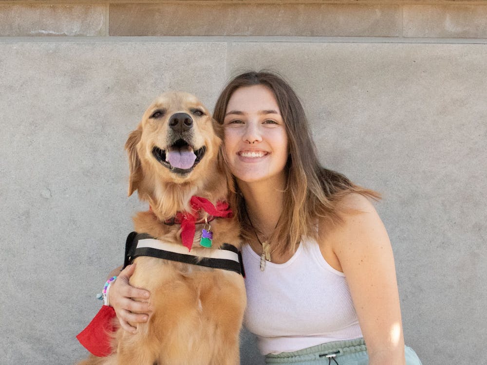 Sara Harmeyer and her golden retriever, Rey, sit proudly under the bells of Shafer Tower Oct. 1. “[Rey] goes longboarding with me and we go on lots of walks,” Harmeyer said. “She also gets lots of attention and play time from me and my friends.” Tori Smith, DN.