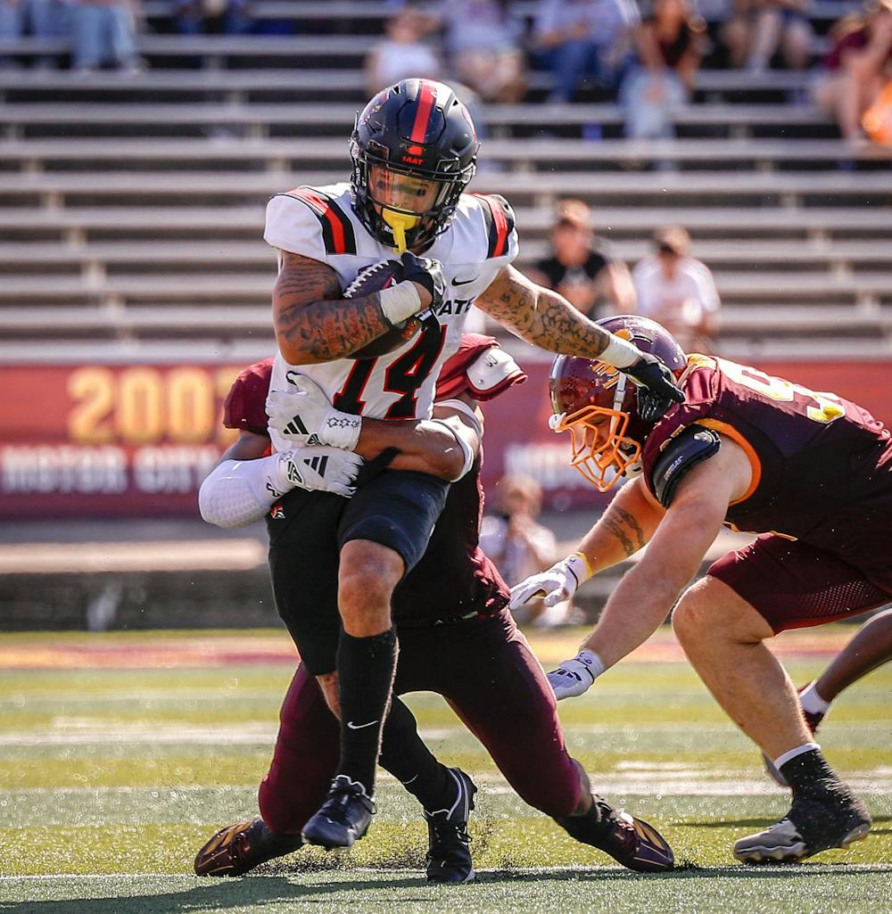 Senior running back Braedon Sloan fights off defenders as he runs against Central Michigan University Sept. 21 at Kelly/Shorts Stadium. Sloan rushed for 94 yards in total. Andrew Berger, DN 