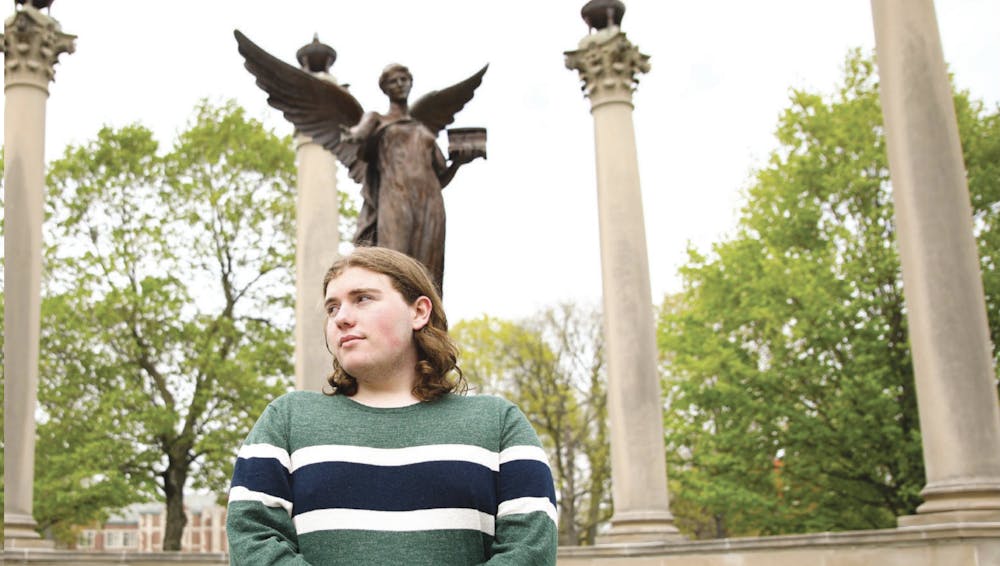 <p>Fourth-year magazine journalism major Evan Chandler poses for a photo in front of Beneficence April 22. Jacy Bradley, DN</p>