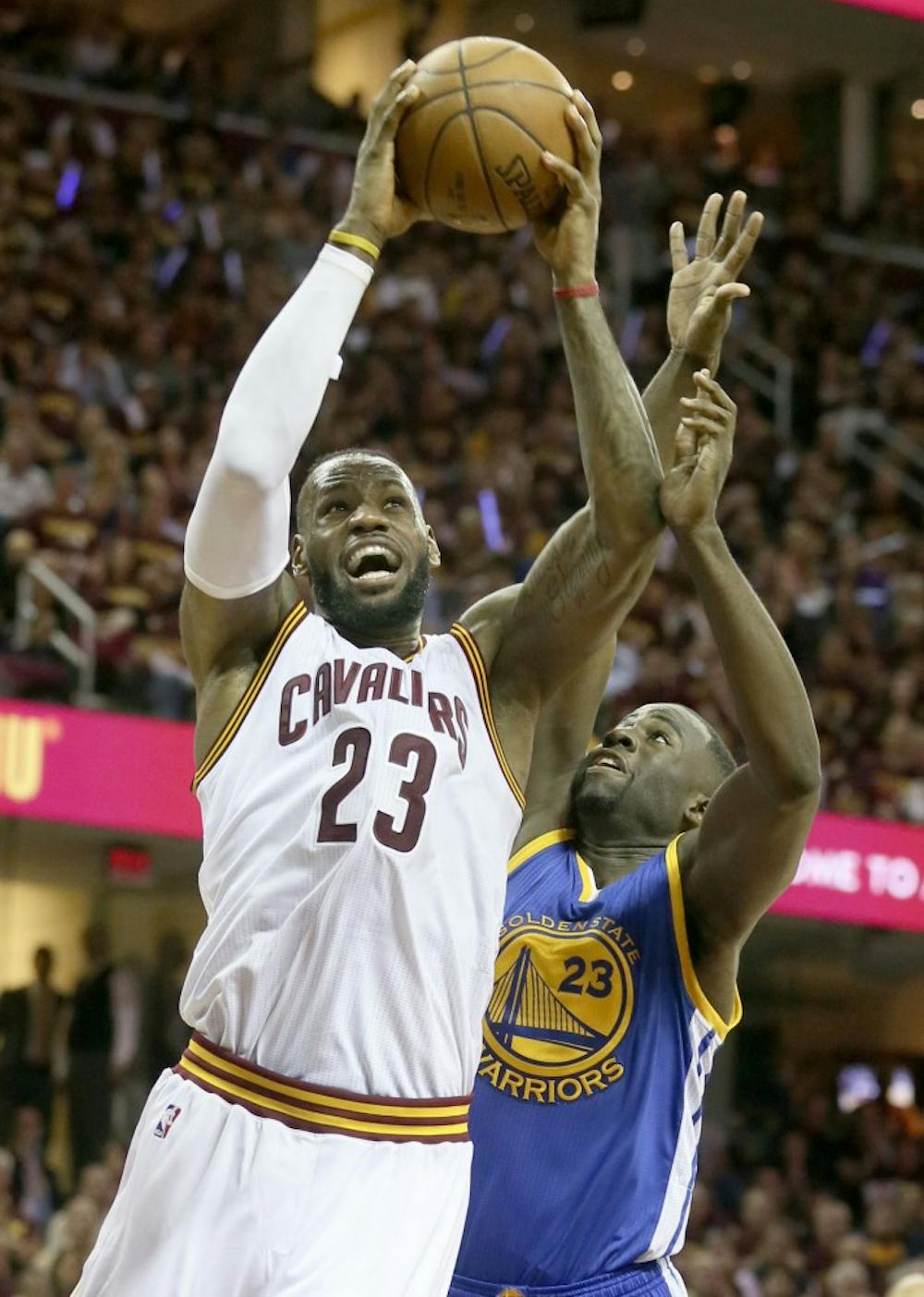 The Cleveland Cavaliers' LeBron James, left, drives to the basket as the Golden State Warriors' Draymond Green defends during the second quarter of Game 6 of the NBA Finals at Quicken Loans Arena in Cleveland on Tuesday, June 16, 2015. The Warriors won, 105-97, to clinch the championship. (Phil Masturzo/Akron Beacon Journal/TNS)