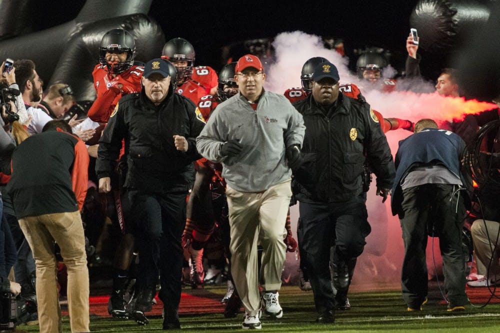 Coach Pete Lembo rushes out onto the field with the Ball State Football team before the game on Wednesday. Ball State lost the game 35-21. DN PHOTO JONATHAN MIKSANEK