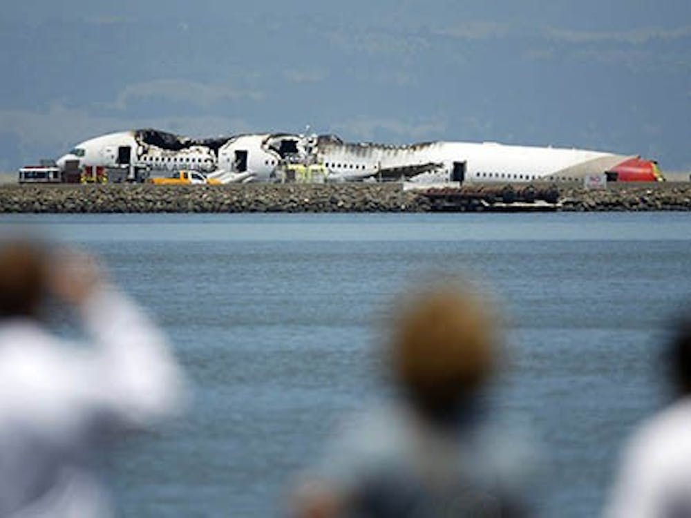 Onlookers view the Asiana Airlines Boeing 777 that crashed on landing at San Francisco International Airport on Saturday. There were about 300 people on board, two of which died as a result of the crash. MCT PHOTO