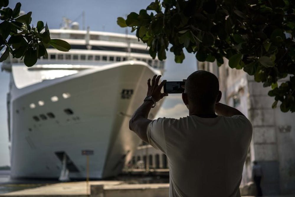<p>FILE - In this June 17, 2017, file photo, a man takes a photo of a cruise ship in Havana harbor, Cuba. President Donald Trump announced a new policy in June that partially rolled back the recent diplomatic opening with Cuba. New regulations implementing that policy are being unveiled Wednesday. <strong>AP, Photo Courtesy&nbsp;</strong></p>