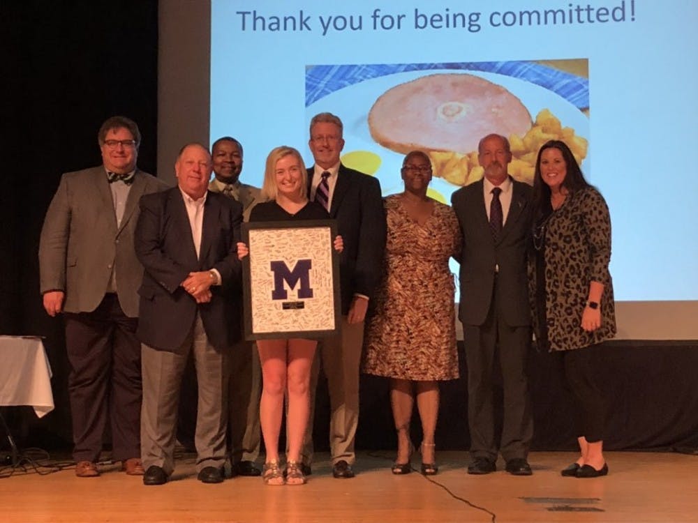 Allison Polk, Muncie Central High School (MCHS) graduate from the class of 2019, poses for a photo along with other members of Muncie Community Schools board of trustees Aug. 28, 2019, at the board's meeting in the MCHS auditorium. Polk presented the board with the MCHS Varsity “M” an award signed by students from the class of 2019. Chris Walker, Photo Courtesy