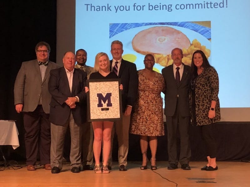 Allison Polk, Muncie Central High School (MCHS) graduate from the class of 2019, poses for a photo along with other members of Muncie Community Schools board of trustees Aug. 28, 2019, at the board's meeting in the MCHS auditorium. Polk presented the board with the MCHS Varsity “M” an award signed by students from the class of 2019. Chris Walker, Photo Courtesy