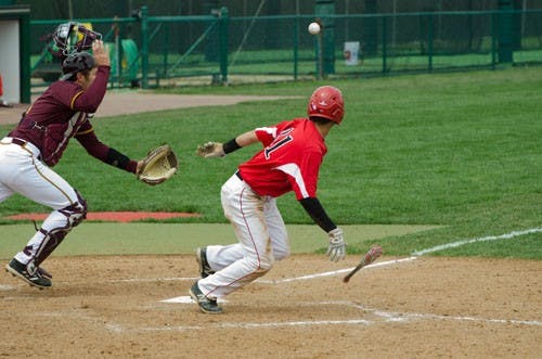 Ball State sophomore Elbert Devarie bunts and runs as Central Michigan catcher Tyler Huntey scrambles to retrieve the ball in the Cardinals' win over the Chippewas on April 13. DN PHOTO WILLIAM STRICKER