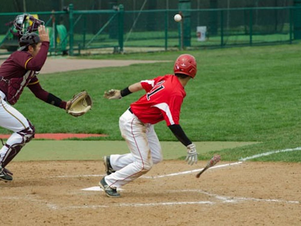 Ball State sophomore Elbert Devarie bunts and runs as Central Michigan catcher Tyler Huntey scrambles to retrieve the ball in the Cardinals' win over the Chippewas on April 13. DN PHOTO WILLIAM STRICKER