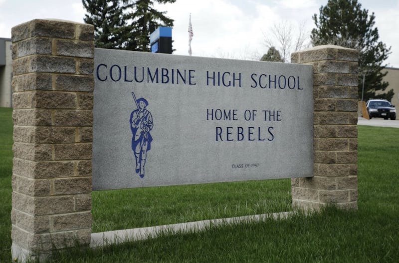 A patrol car is parked in front of Columbine High School, Wednesday, April 17, 2019, in Littleton, Colo., where two student killed 12 classmates and a teacher in 1999. The school was closed along with hundreds of others in Colorado after an armed young Florida woman who was allegedly "infatuated" with Columbine threatened violence just days ahead of the 20th anniversary of the attack. (AP Photo/Joe Mahoney)