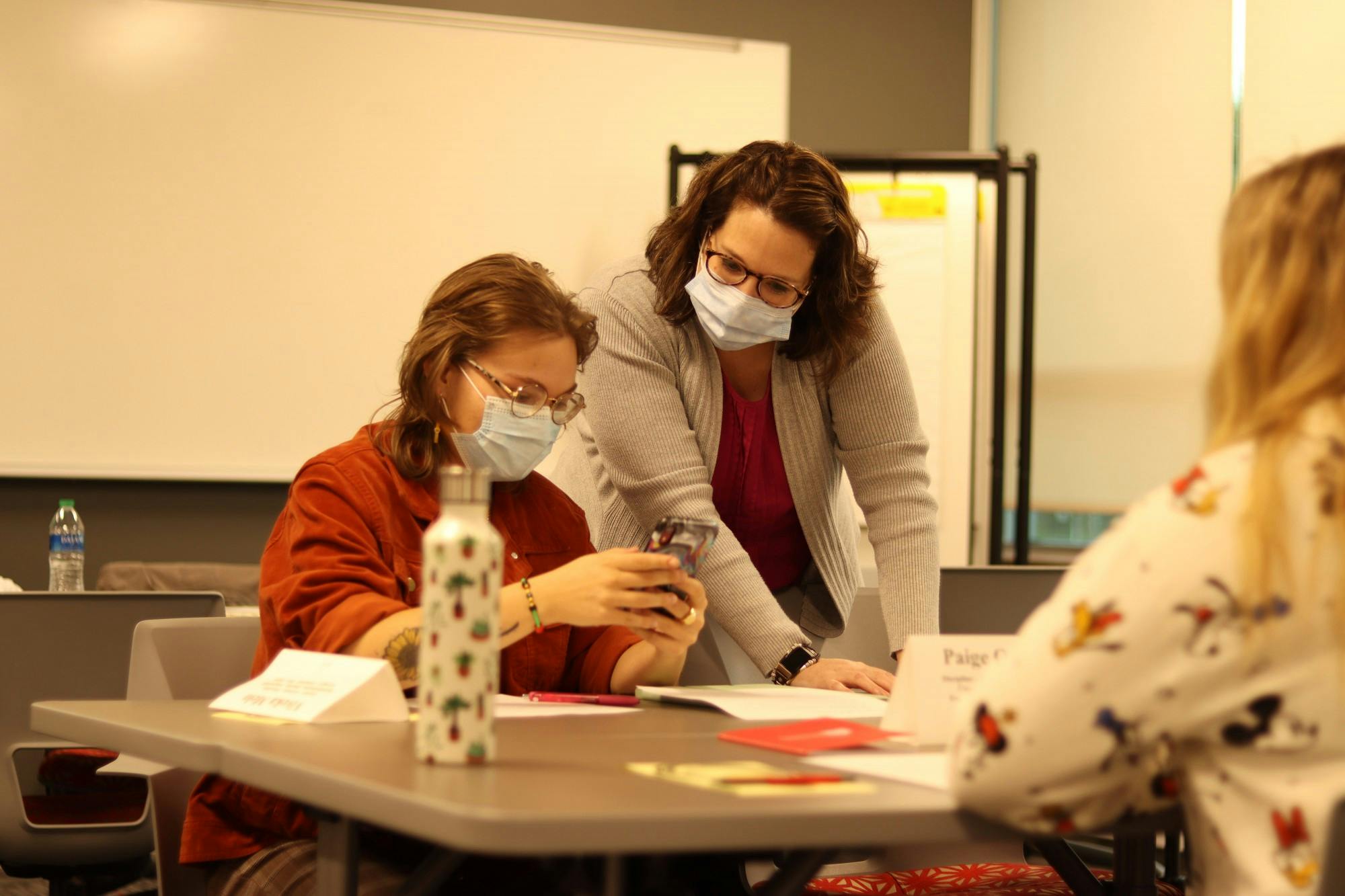 Before the &quot;Gen: i&quot; meeting begins Sept. 23, Viveka Melo shows Charity Coffman, associate program director at the Entrepreneurial Leadership Institute, something on her phone. The &quot;Gen: i&quot; group meets twice per month. Elissa Maudlin, DN