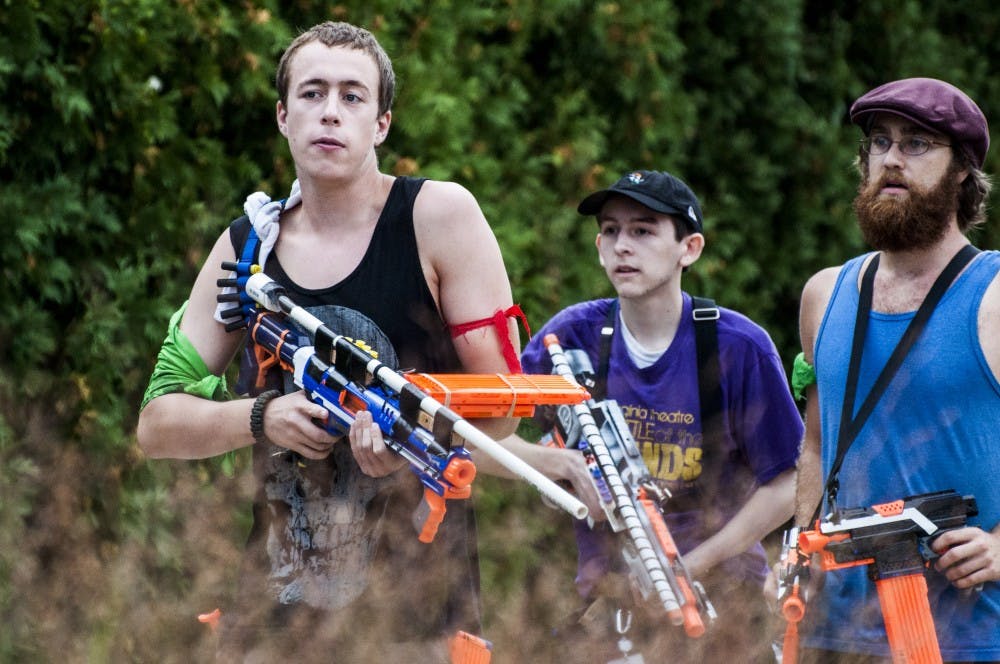 Humans rush to back up another team holding a position behind the David Letterman Communication and Media Building as others search for numbers for a combination lock during the 