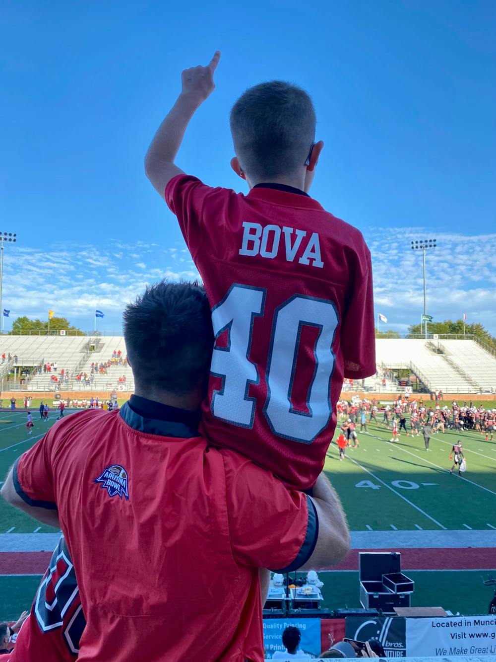 Ball State Alumni Garrett Bova watches Ball State football warm-up with his son Brody Bova on his shoulder Oct.1, 2022 at Scheumann Stadium. Dannie Bova, Photo provided