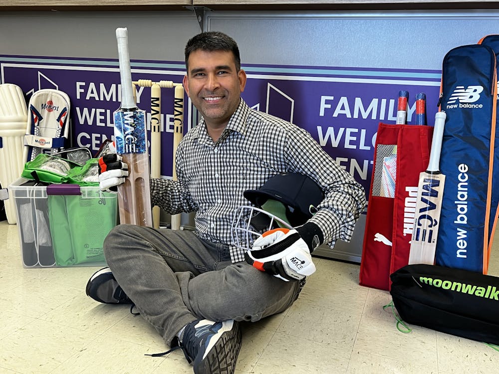 <p>Siddiq Reshtya, a global academy teacher at Muncie Community Schools, shows off the cricket gear that will be available for players to use during the weekly Family Cricket Club events.</p>