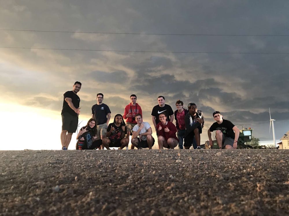 The 2021 Storm Chasing team poses for the camera after a long day of storm chasing on May 20. Mammataus clouds, clouds formations that have a series of bulges,  pose behind them. Rachel Wynalda, Photo Provided.