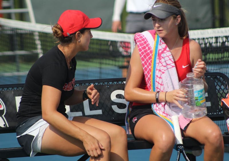 Graduate Assistant Carmen Blanco talks to senior Sarah Swinderski during her first round of singles matches against Detroit Mercy at Cardinal Creek Tennis Center. Swinderski won the first set of the match 6-4. Patrick Murphy,DN