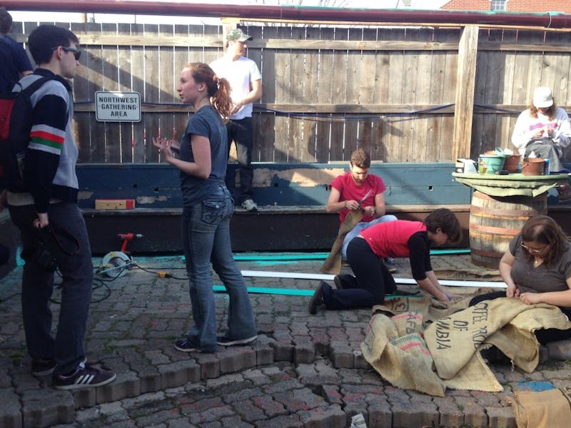 Faye Lichtsinn, a junior Natural Resources and Environmental Management major at Ball State University, talks to a Permaculture Initiative volunteer about the process of building a fence garden and drainage system at Be Here Now.