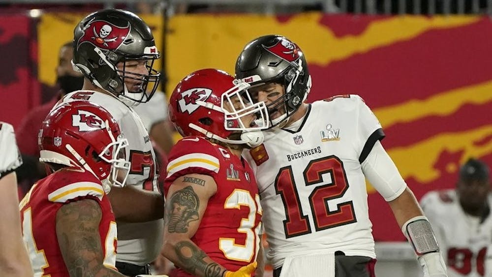 Tampa Bay Buccaneers quarterback Tom Brady (12) talks with Kansas City Chiefs strong safety Tyran Mathieu (32) after throwing a touchdown pass of the NFL Super Bowl 55 football game Sunday, Feb. 7, 2021, in Tampa, Fla. (AP Photo/Gregory Bull) 
