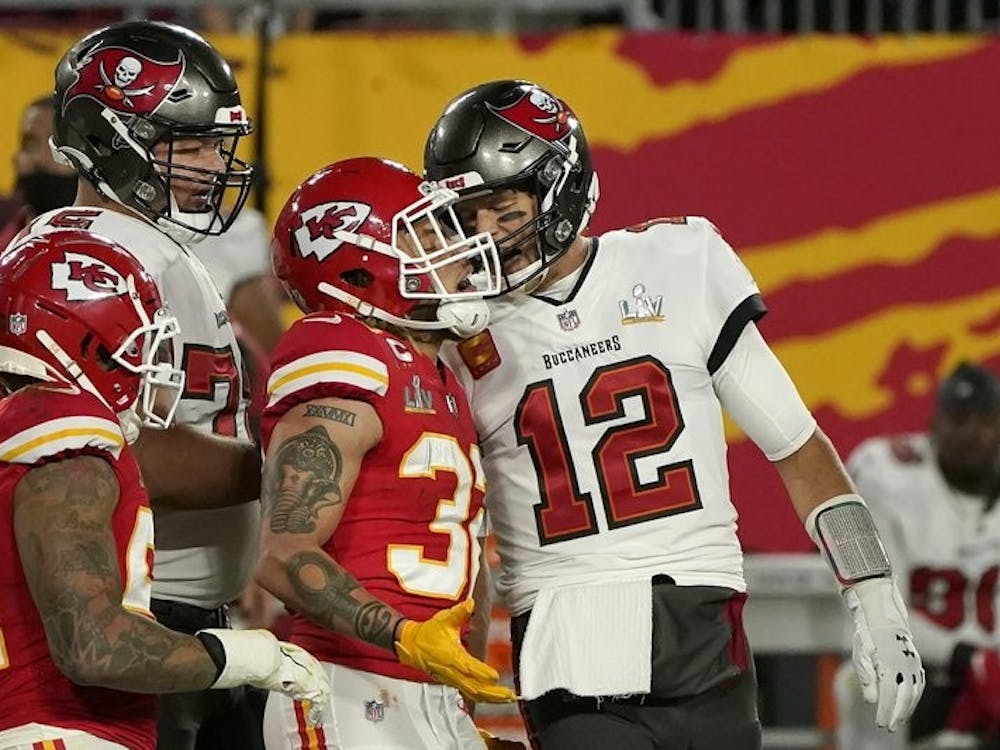 Tampa Bay Buccaneers quarterback Tom Brady (12) talks with Kansas City Chiefs strong safety Tyran Mathieu (32) after throwing a touchdown pass of the NFL Super Bowl 55 football game Sunday, Feb. 7, 2021, in Tampa, Fla. (AP Photo/Gregory Bull) 