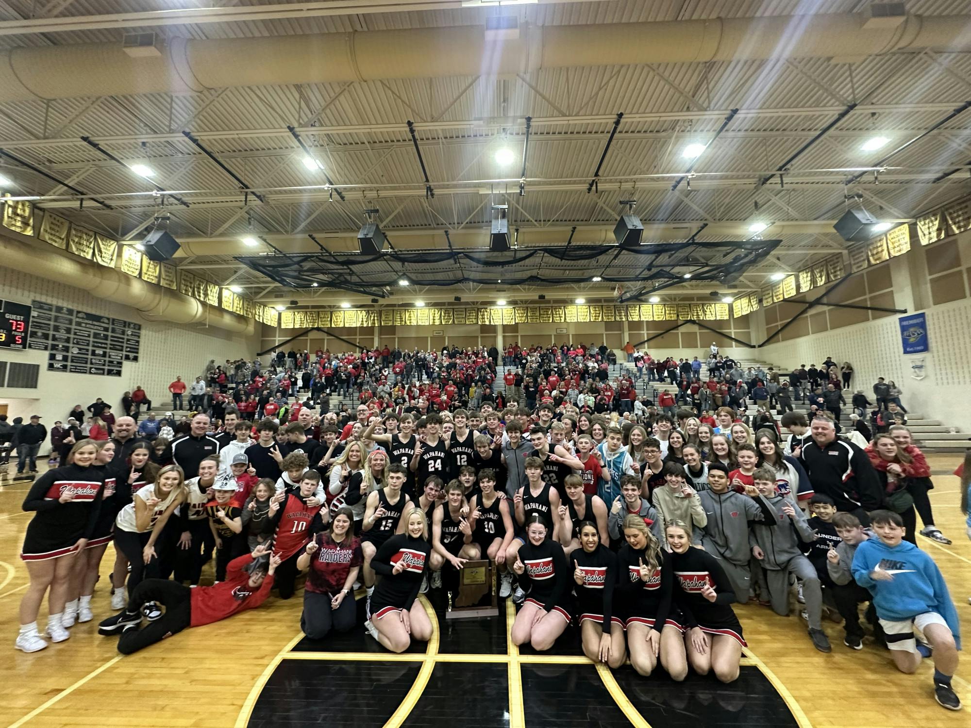 Wapahani players, coaching staff, students and fans pose with the Regional Championship trophy after the boys' basketball team defeated Carroll (Flora) 73-50 in the #20 2A Regional Championship March 11. Daniel Kehn, DN