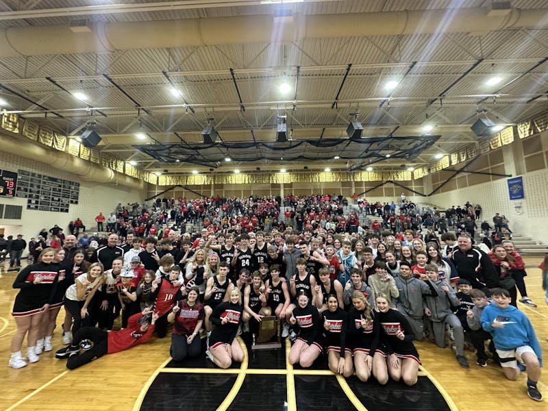 Wapahani players, coaching staff, students and fans pose with the Regional Championship trophy after the boys' basketball team defeated Carroll (Flora) 73-50 in the #20 2A Regional Championship March 11. Daniel Kehn, DN