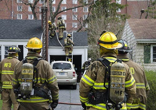 Muncie firefighters respond to a fire at 1513 N. Woodridge Ave. A cooking fire spread from the kitchen up the stove ventilation to the attic. The owner of the house was sent to Ball Memorial Hospital for potential smoke inhalation and burns from the grease fire. DN PHOTO COREY OHLENKAMP