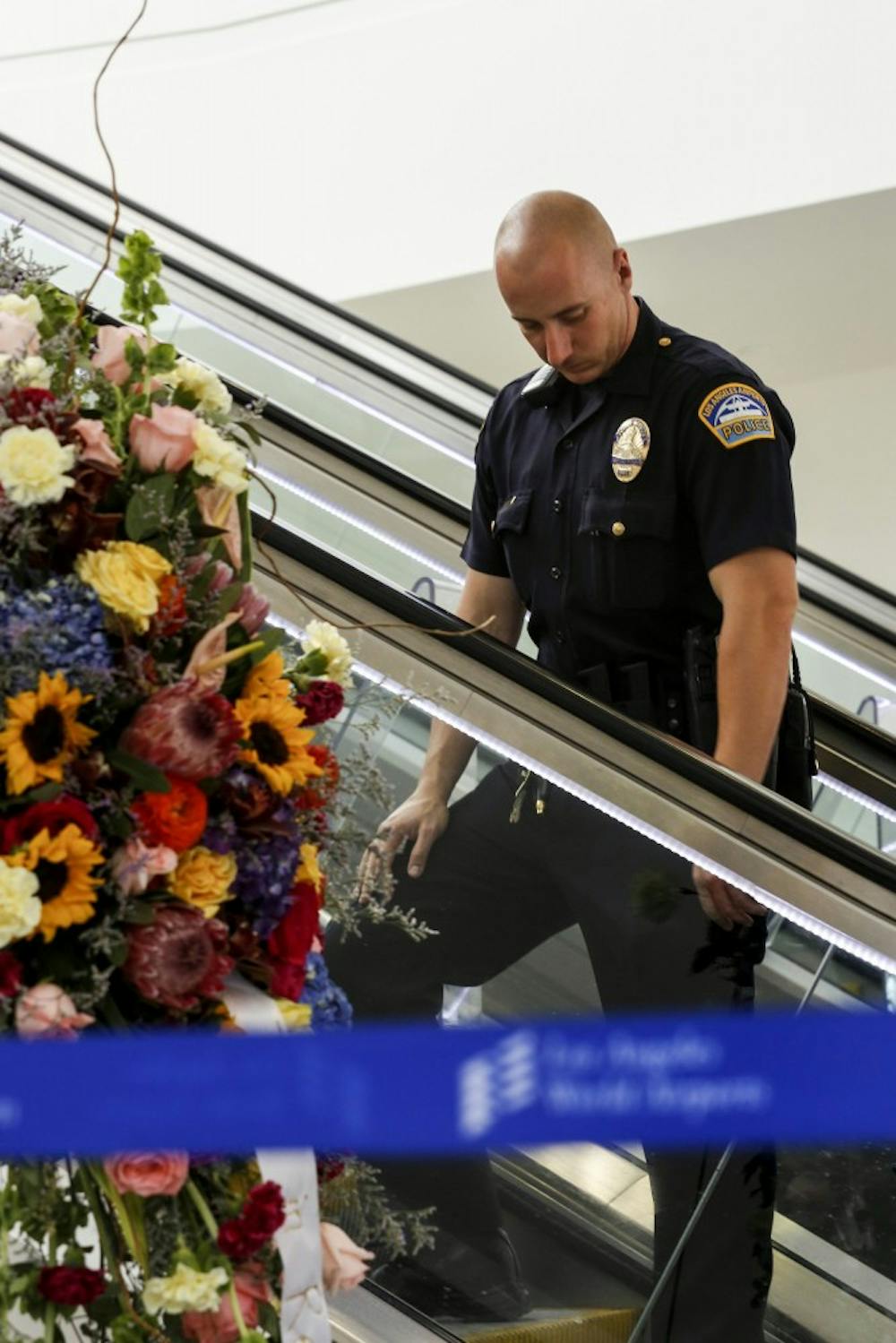 An Los Angeles Airport Police officer passes by a flower memorial in terminal three for slain TSA officer Gerardo Hernandez at LAX on November 3, 2013, in Los Angeles, California. (Jay L. Clendenin/Los Angeles Times/MCT)