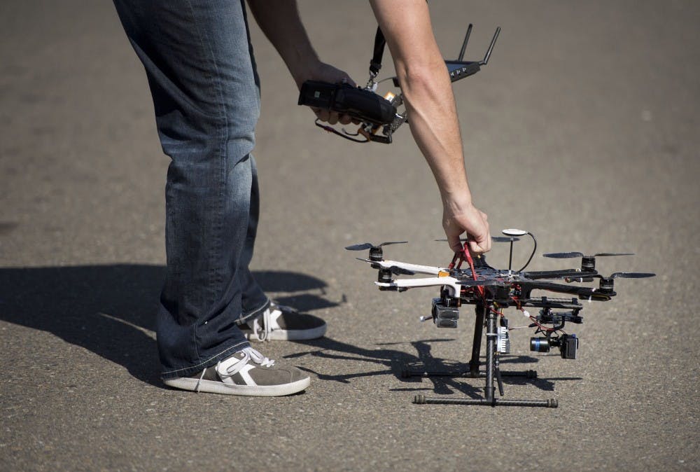 Christopher Brown, co-owner of Next New Homes Group, reaches for his multi-rotor helicopter drone after taking aerial video of a home in Sacramento, Calif., on February 25, 2014. Drones are increasingly being used by small companies to shoot videos for real estate, car commercials, weddings, sports events, and other instances where aerial shots are needed. (Randy Pench/Sacramento Bee/MCT)