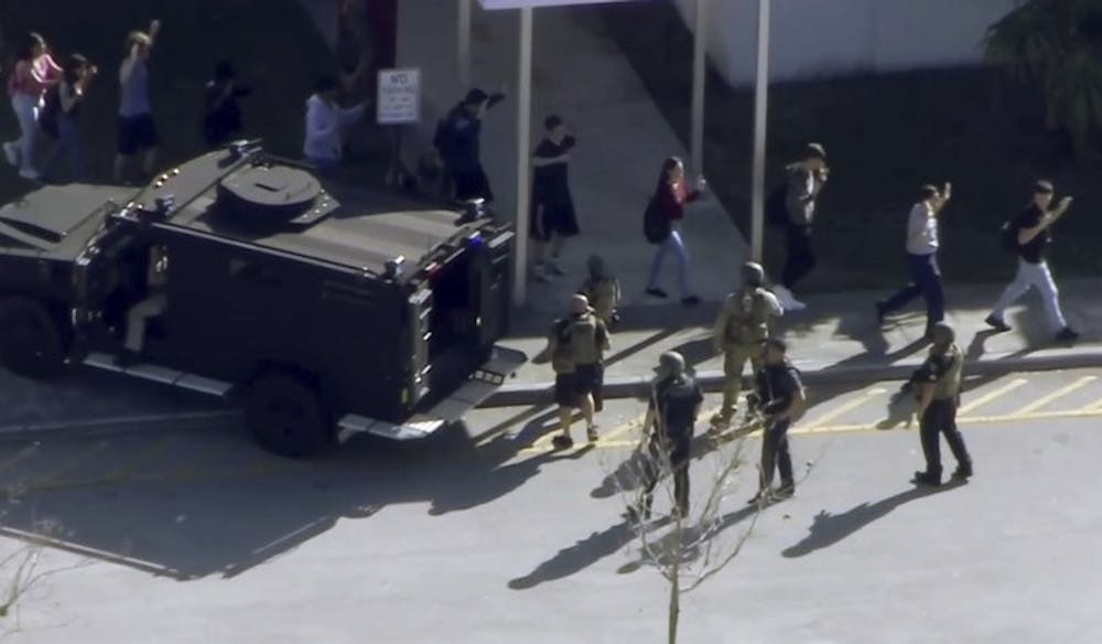 In this frame grab from video provided by WPLG-TV, students from the Marjory Stoneman Douglas High School in Parkland, Fla., evacuate the school following a shooting, Wednesday, Feb. 14, 2018. Associated Press