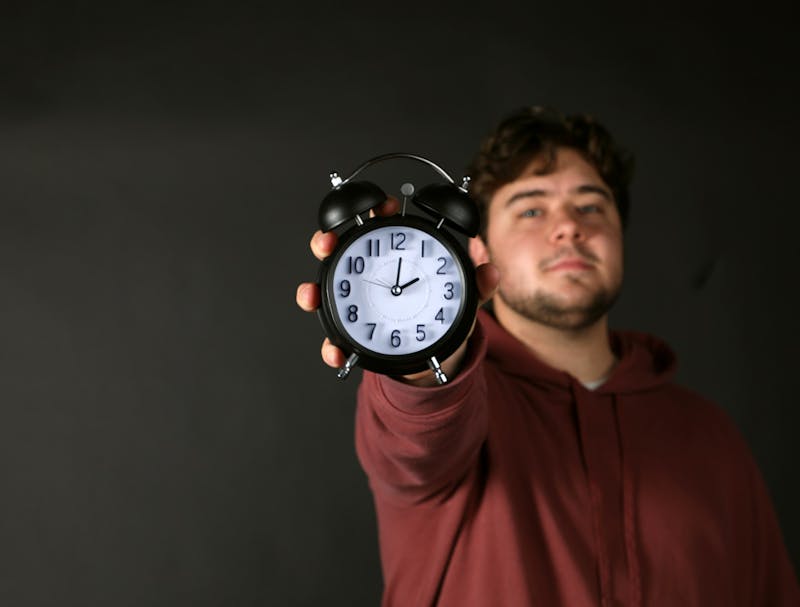 Sports Editor Daniel Kehn poses with a clock Nov. 1 in the photojournalism studio. Amber Pietz, DN