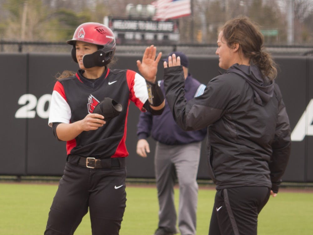 <p>Ball State senior Maddy Labrador, left, high fives volunteer assistant coach Rachel Houck during the first game against Central Michigan April 21 at the softball field at First Merchant’s Ballpark Complex. Ball State won the first game 2-1. <strong>Briana Hale, DN</strong></p>