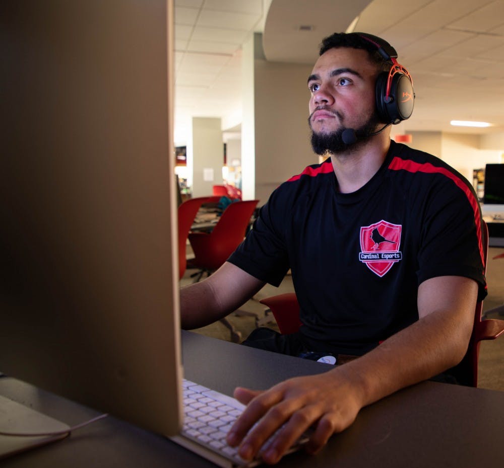 <p>Jullian Thomas sits in front of a computer. Thomas is wearing his headset and Cardinal Esports jersey. <strong>Jacob Musselman, DN</strong></p>