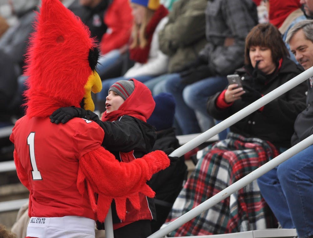 Charlie Cardinal hugs a child during the game against Toledo on Oct. 3 at Scheumann Stadium. Charlie Cardinal interacted with fans throughout the competition. DN PHOTO JASON CONERLY